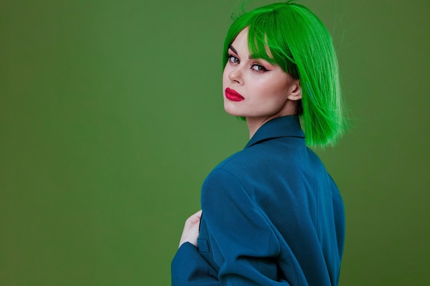Bellezza Moda donna che indossa una parrucca verde giacca blu in posa sfondo verde inalterato