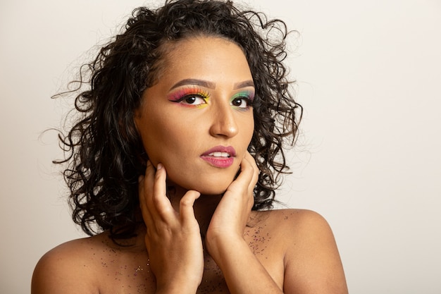 Bellezza modella ragazza con i capelli ricci e trucco colorato. Donna afro che sorride alla macchina fotografica