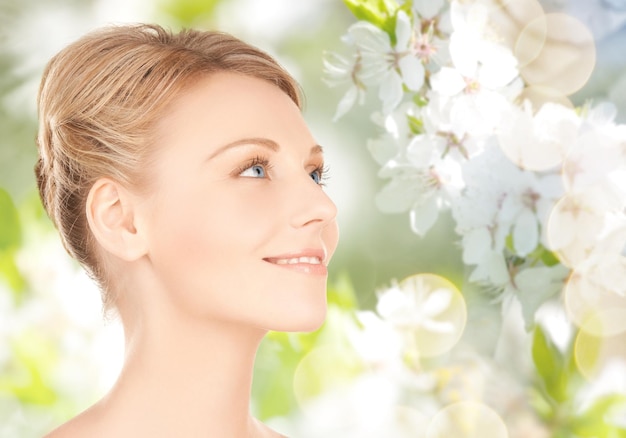 bellezza, persone, estate, primavera e concetto di salute - bella giovane donna faccia su sfondo verde giardino fiorito