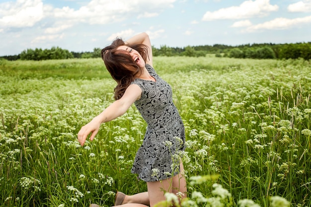 Bellezza ragazza all'aperto godersi la natura in estate Campo con fiori selvatici in fiore