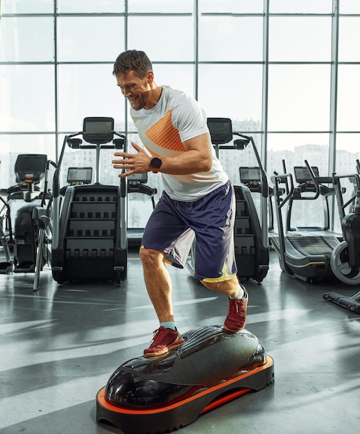 Belli uomini muscolosi si allenano su una piattaforma morbida di allenamento funzionale in palestra