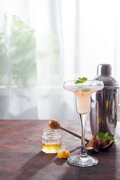 Bellini cocktail con pesche e fichi, miele su sfondo chiaro su windows, copia spazio