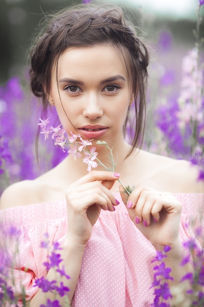 Bellissima giovane donna con fiori. Ritratto di donna attraente da vicino