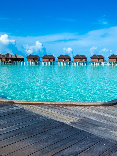 Bellissima isola tropicale delle Maldive con spiaggia. Mare con bungalow sull'acqua