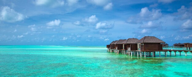 Bellissima isola tropicale delle Maldive con spiaggia. Mare con bungalow sull'acqua