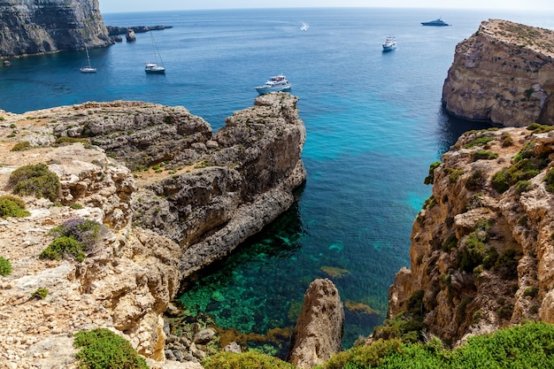 Bellissima laguna blu con acque turchesi, yacht e barche in una soleggiata giornata estiva. Comino, Malta