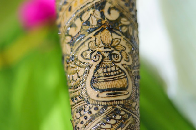 Bellissima opera d'arte disegnata sulla mano di una sposa indiana con heena alle erbe in condizioni di bagnato