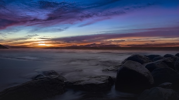 Bellissima spiaggia al tramonto con rocce