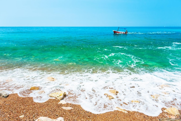 Bellissima spiaggia con acqua turchese e barca in riva al mare. Mare Adriatico, Montenegro.