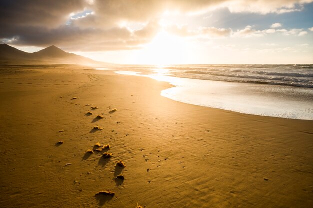 Bellissima spiaggia senza nessuno per destinazione panoramica tropicale - vacanze estive - bel tramonto sulla riva con montagne e onde