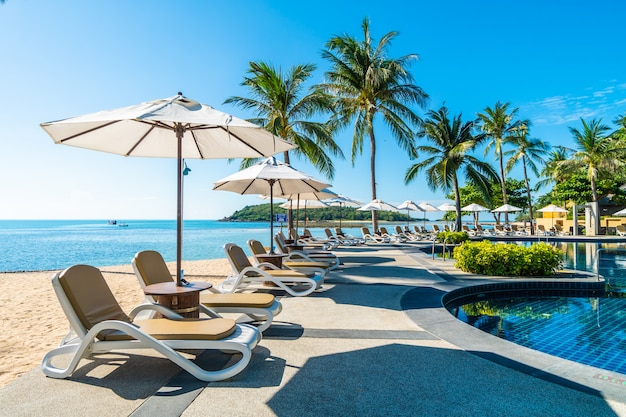 Bellissima spiaggia tropicale e mare con ombrellone e sdraio in piscina