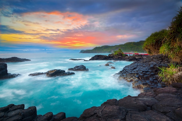 bellissima vista con rocce e colline durante il fantastico tramonto sulla spiaggia di Menganti, nel centro di Java?