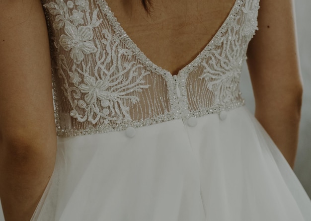 Bellissima vista dell'abito da sposa in pizzo sulla schiena nuda della sposa, vista laterale da vicino