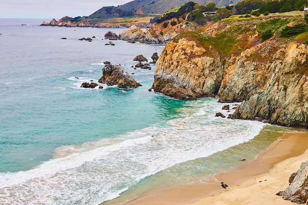 Bellissime onde oceaniche che si schiantano contro la costa con scogliere e scogliere gialle