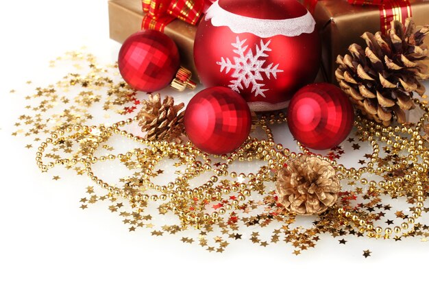 Bellissime palle di Natale rosse, regali e coni isolati su bianco
