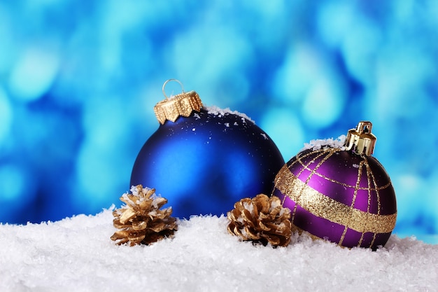 Bellissime palle e coni di Natale blu e viola nella neve