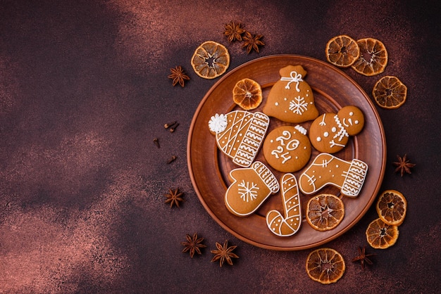 Bellissimi biscotti di pan di zenzero di Natale di diversi colori su un piatto di ceramica