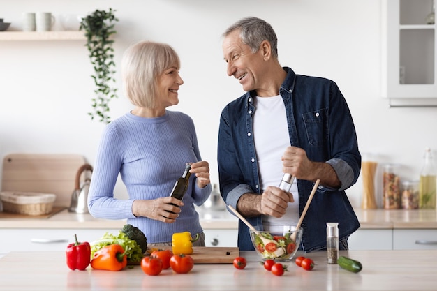 Bellissimi coniugi senior che preparano una cena sana insieme a casa