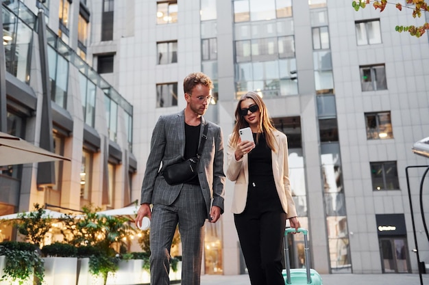 Bellissimi edifici commerciali Donna e uomo in città durante il giorno Gente ben vestita