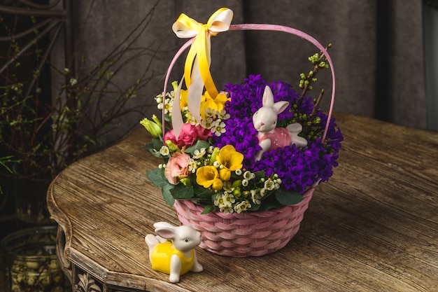 Bellissimi fiori e conigli su un cesto di vimini