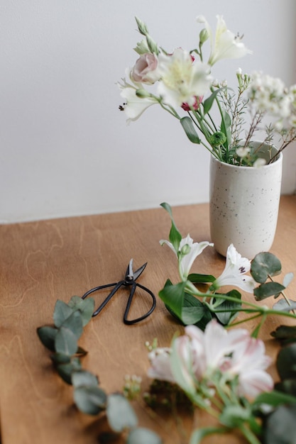 Bellissimi fiori freschi e forbici su fondo in legno composizione floreale Bouquet moderno di primavera