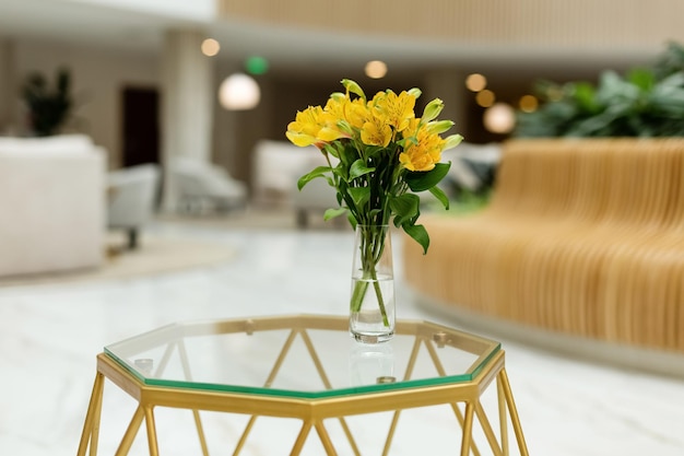 Bellissimi fiori gialli primaverili in un vaso in piedi nel soggiorno sul tavolino da caffè Casa moderna e accogliente