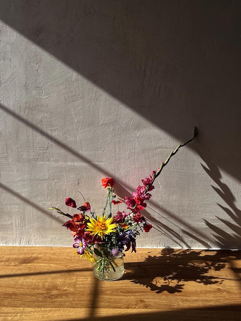 Bellissimi fiori in vaso alla luce del sole sullo sfondo di un muro rurale Eleganti fiori ancora in vita in casa composizione artistica Estetica del bouquet estivo