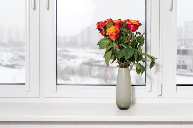 Bellissimi fiori in vaso con luce dalla finestra