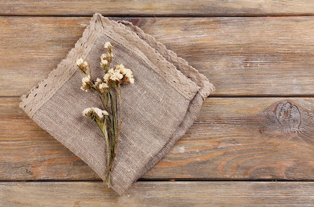 Bellissimi fiori secchi sul tovagliolo su fondo di legno