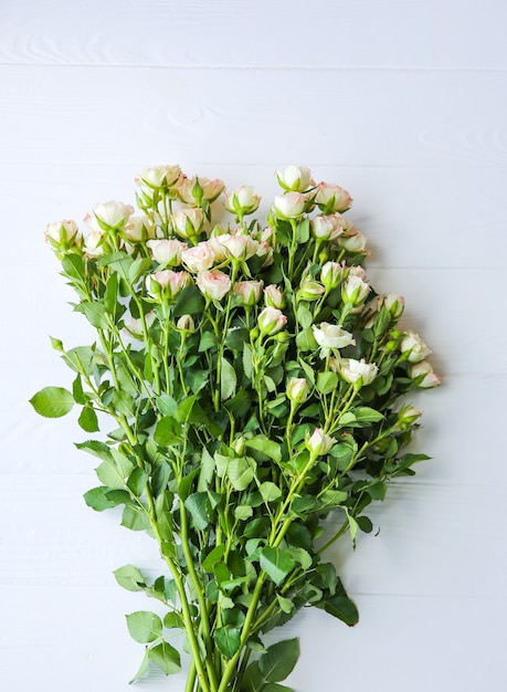 Bellissimi fiori su sfondo bianco. Mazzo di rose. Posa piatta perfetta. Cartolina di festa della madre felice. Saluto per la giornata internazionale della donna. Idea elegante per pubblicità o promozione.