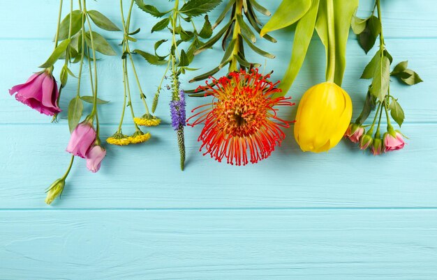 Bellissimi fiori su sfondo di legno blu