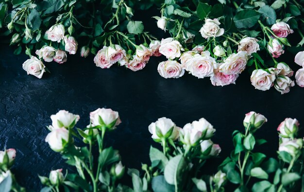 Bellissimi fiori su sfondo nero. Mazzo di rose. Posa piatta perfetta. Cartolina di festa della madre felice. Saluto per la giornata internazionale della donna. Idea elegante per pubblicità o promozione.