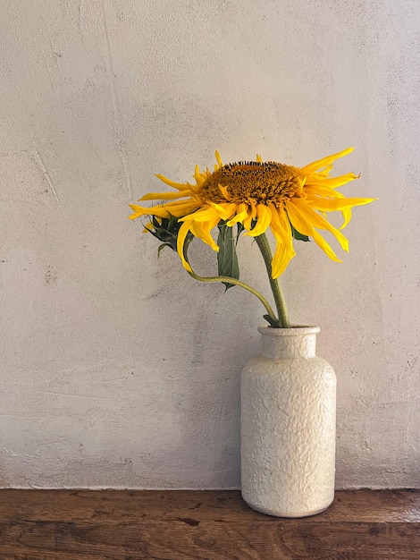 Bellissimi girasoli in vaso su fondo rustico Elegante fiore natura morta estate composizione artistica Carta da parati floreale verticale