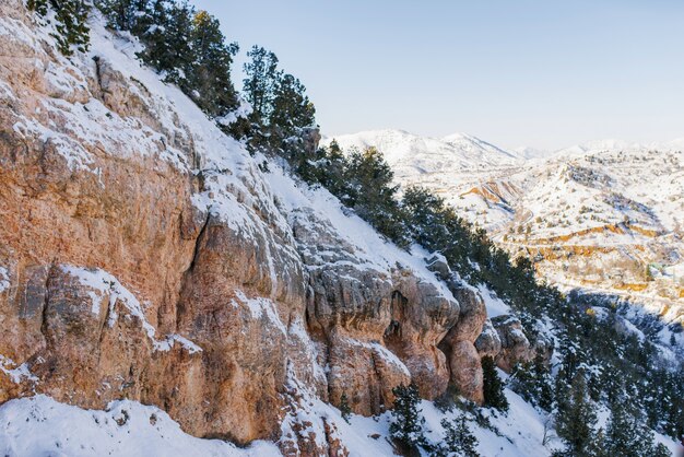 Bellissimi pendii della montagna di roccia rossa ricoperti di neve nella zona della località di Beldersay in Uzbekistan