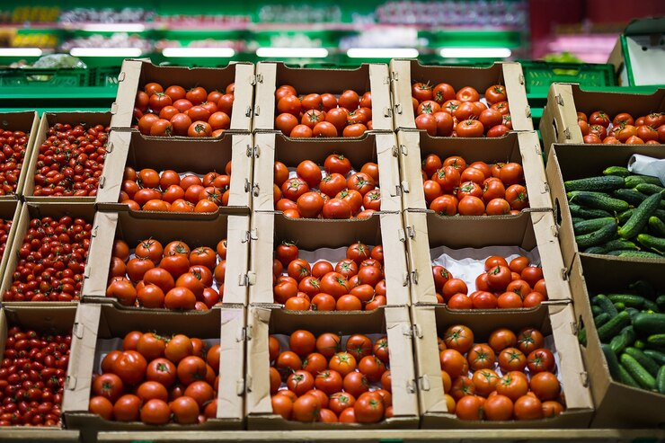 Bellissimi pomodori rossi in scatole di cartone, in vendita su uno scaffale di mercato.