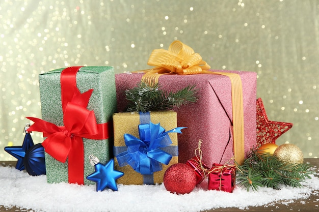 Bellissimi regali luminosi e decorazioni natalizie, su sfondo lucido