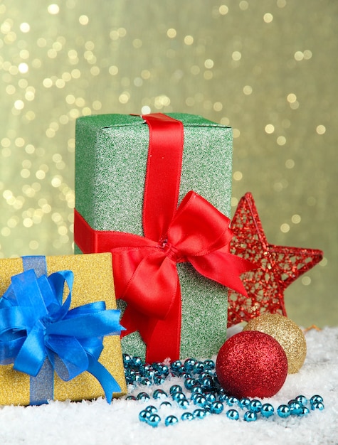Bellissimi regali luminosi e decorazioni natalizie, su sfondo lucido