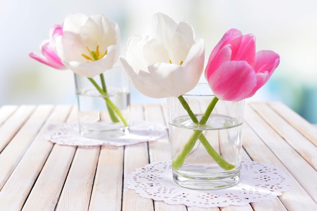 Bellissimi tulipani in secchio in vaso sul tavolo su sfondo chiaro