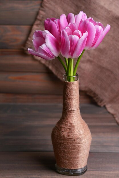 Bellissimi tulipani in secchio in vaso sul tavolo su sfondo grigio