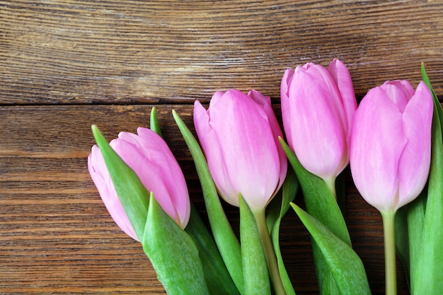 Bellissimi tulipani rosa su fondo di legno