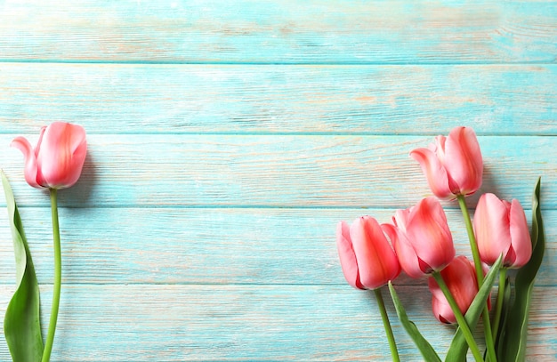 Bellissimi tulipani sullo sfondo del tavolo in legno