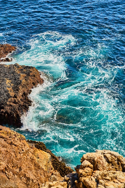 Bellissimi turbinii di acqua oceanica dalla costa rocciosa