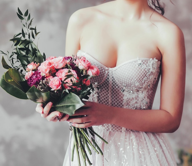 Bellissimo abito da sposa stile perfetto per la sposa e bouquet da sposa