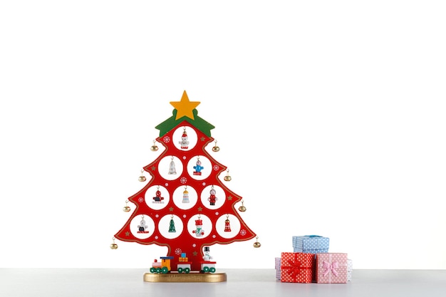 Bellissimo albero di Natale in legno con giocattoli di colore rosso su sfondo bianco