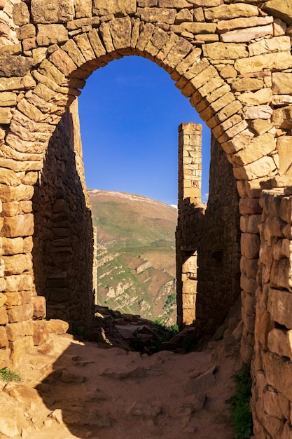 Bellissimo arco in pietra tra le rovine dell'antico villaggio abbandonato di Gamsutl Daghestan