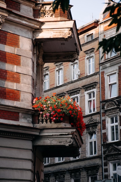 Bellissimo balcone antico con fiori rossi in stile romantico