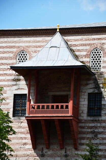 Bellissimo balcone in legno con tetto conico Un antico edificio in pietra con balcone