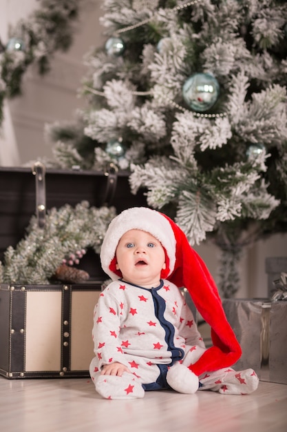 Bellissimo bambino festeggia il Natale. Vacanze di Capodanno. Bambino in costume di Natale con regalo