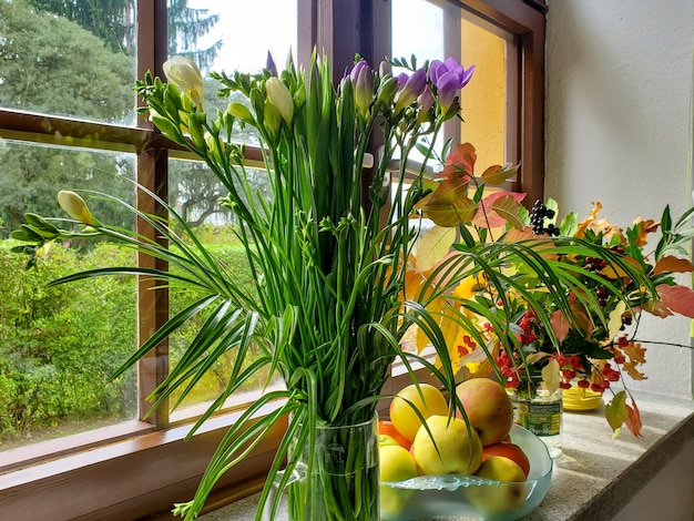 Bellissimo bouquet autunnale sul davanzale della finestra, fiori, foglie, bacche, blocchi. Foto di alta qualità