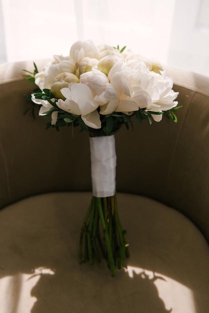 Bellissimo bouquet da sposa bianco di peonie sotto i raggi del sole